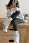 Front view of model posing in slouchy, pull on pearl grey luxe knit Leg Warmers that can be worn pulled up on scrunched down
