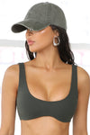 Side view of model wearing the six-panel washed green Official Cap with a curved brim and an embroidered upside down Joah Brown logo on the front