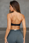Back view of model posing in the smoothing and stretchy sueded onyx Corded Smoothing Bra with a low square back and ultra thin corded straps