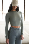 Front view of model posing in the fitted cropped summit rib Cropped Crew Long Sleeve top with a crew neckline