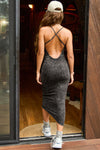 Full body back view of model posing in the fitted charcoal washed rib Cross Back Midi Dress with an asymmetrical hem, a low scoop back and thin adjustable straps that criss cross in the back