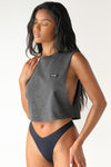 Front view of model posing in the relaxed fit washed black cotton Cut Off Boyfriend Tank with low cut armholes, a crew neckline and a joah brown logo patch at the upper left chest