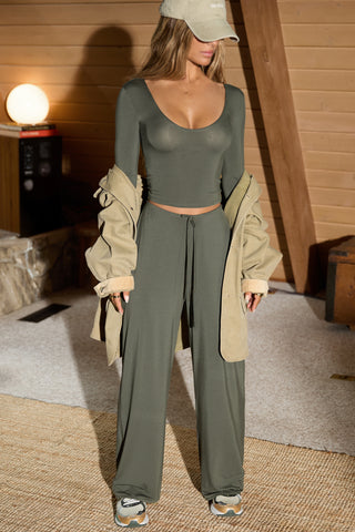 Full body front view of model posing in the relaxed fit spruce modal Relaxed Straight Leg Pant with a wide leg, elastic waistband, adjustable drawstring tie and subtle pleating at the sides.