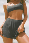Close up front view of model posing in the soft and comfortable charcoal luxe knit Relaxed Short with an elastic waistband and relaxed fit