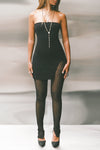Front view of model posing in the sheer high-waisted black mesh Split Hem Legging with gathered ankles, exposed seams and button closures at the leg opening