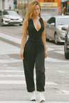 Full body front view of model posing outside in the street in the form fitting black flexrib Invisible Zip Tank top with a front invisible zipper and a crew neckline