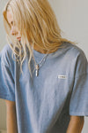 Front view of model posing in the relaxed fit denim cotton Oversized Crew Tee with a crew neckline and joah brown logo patch on the upper left side