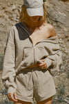 Front view of model posing outside in the oversized comfortable sand french terry Oversized Zip Hoodie with a full length front zip closure, side pockets and thumbholes in the fitted cuffs