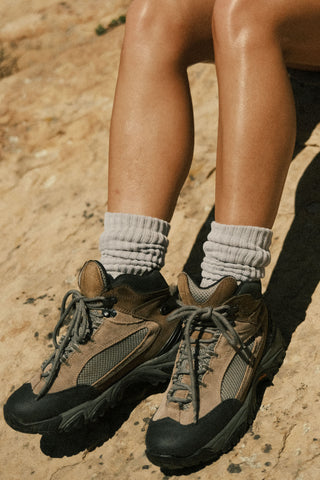 Close up front view of model wearing the slouchy salt Scrunch Sock with extra long ribbed cuffs