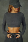 Front view of model posing in the reversible wrap-around ultra cropped charcoal luxe knit Wrap Cardigan with adjustable ties and fitted sleeves with thumbholes
