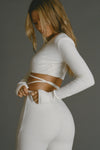 Back view of model posing in the mid-rise fitted natural luxe knit Fitted Mini Flare Pant with a slightly flare leg
