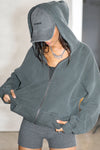 Front view of model posing in the oversized comfortable evergreen french terry Oversized Zip Hoodie with a full length front zip closure, side pockets and thumbholes in the fitted cuffs