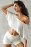Front view of model posing in the cropped, loose fitting chalk model Slouchy Crop Tee with a wide scoop neckline