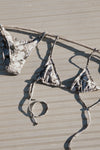 The meadow camo Triangle Bikini Top with adjustable tie straps and the meadow camo Triangle Bikini Bottom laying on a deck