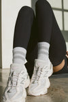 Close up front view of model posing in the crew-style silver Mini Stripe Sock with ribbed cuffs