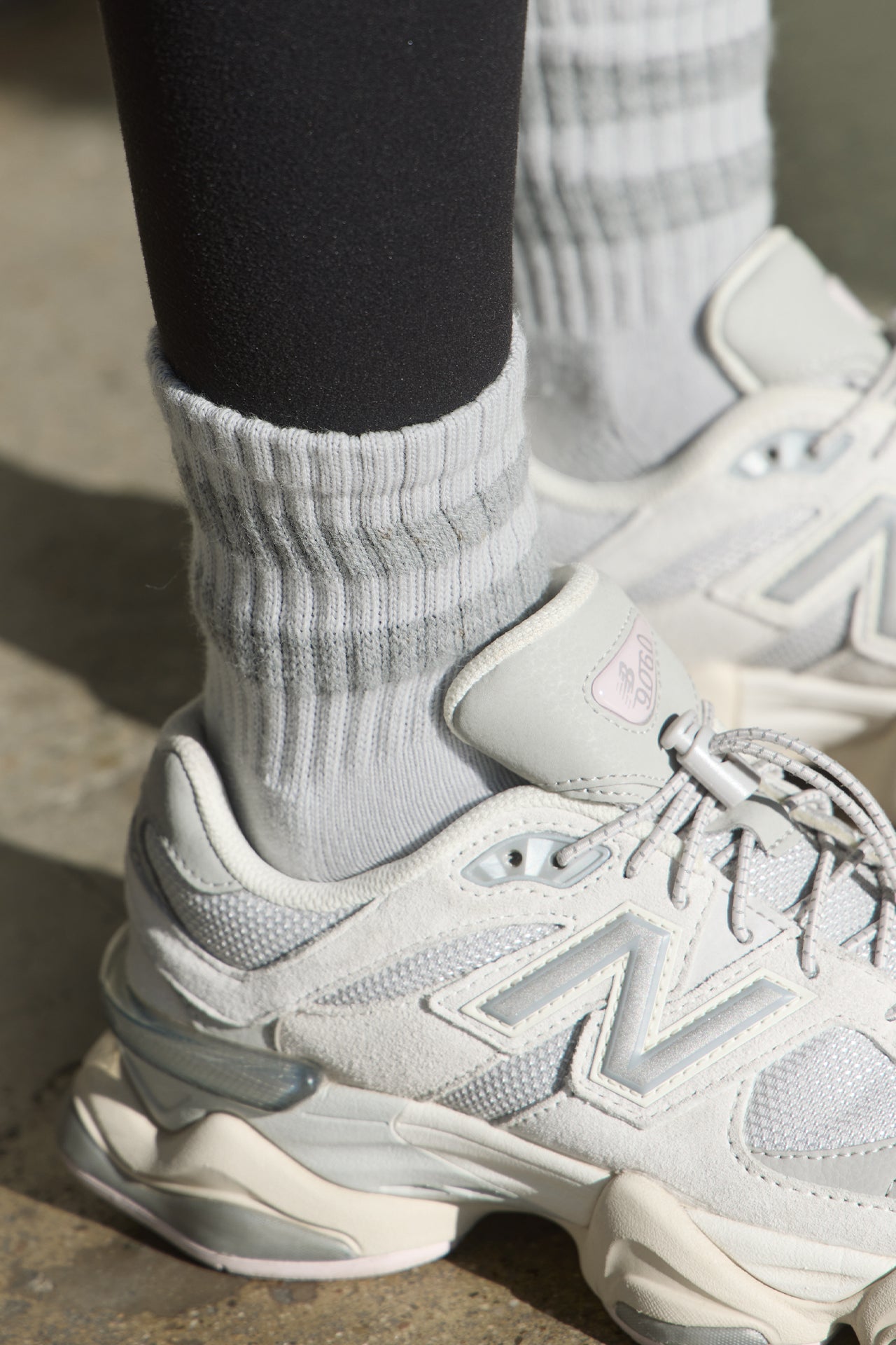 Close up detail side view of model posing in the crew-style silver Mini Stripe Sock with ribbed cuffs