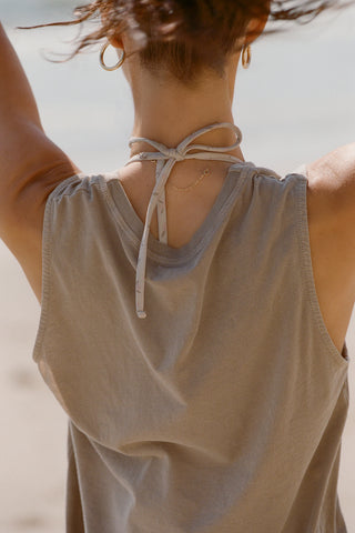 Close up back view front view of model posing on the beach in the relaxed fit sage grey classic cotton Muscle Tank with a crew neckline