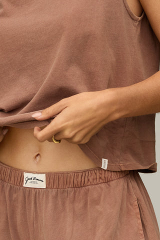 Close up detail front view model from the waist down posing in the relaxed fit tobacco classic cotton Muscle Tank with a crew neckline