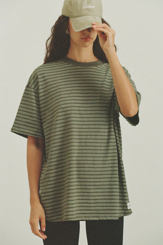 Front view of model posing in the oversized, lightweight forest stripe classic cotton Off-Duty Tee with a crew neckline and dropped shoulders