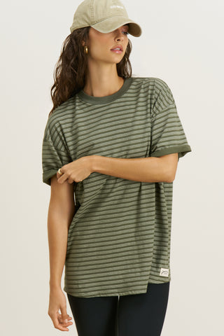 Front view of model posing in the oversized, lightweight forest stripe classic cotton Off-Duty Tee with a crew neckline and dropped shoulders