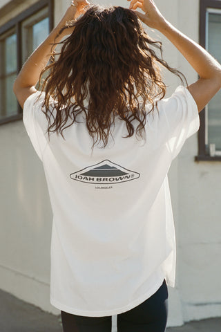 Back view of model posing in the oversized, lightweight optic white classic cotton Off-Duty Tee with a crew neckline and dropped shoulders