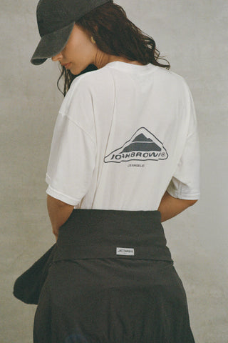 Back view of model posing in the oversized, lightweight optic white classic cotton Off-Duty Tee with a crew neckline and dropped shoulders