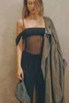 Front view of model posing in the sheer and fitted black mesh Off The Shoulder Bandeau Tank with thin straps and draped sleeves and can be worn off the shoulder or with the sleeves up
