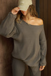 Front view of model posing in the relaxed fit army luxe knit Off Shoulder Tunic with a wide off-the-shoulder neckline and asymmetrical hem