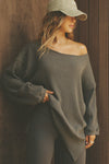 Front view of model posing in the relaxed fit army luxe knit Off Shoulder Tunic with a wide off-the-shoulder neckline and asymmetrical hem