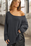 Front view of model posing in the relaxed fit midnight luxe knit Off Shoulder Tunic with a wide off-the-shoulder neckline and asymmetrical hem