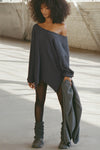 Full body front view of model posing in the relaxed fit midnight luxe knit Off Shoulder Tunic with a wide off-the-shoulder neckline and asymmetrical hem