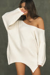 Front view of model posing in the relaxed fit natural luxe knit Off Shoulder Tunic with a wide off-the-shoulder neckline and asymmetrical hem