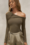Front view of model posing in the fitted woodland rib Off Shoulder Twist Long Sleeve top asymmetrical neckline with a twist detail and off-shoulder design