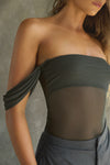 Close up detail front view of model posing in the sheer and fitted graphite mesh Off The Shoulder Bandeau Tank with thin straps and draped sleeves and can be worn off the shoulder or with the sleeves up