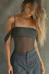 Front view of model posing in the sheer and fitted graphite mesh Off The Shoulder Bandeau Tank with thin straps and draped sleeves and can be worn off the shoulder or with the sleeves up