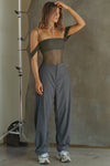 Full body front view of model posing in the sheer and fitted graphite mesh Off The Shoulder Bandeau Tank with thin straps and draped sleeves and can be worn off the shoulder or with the sleeves up
