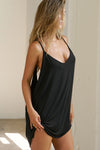 Side view of model posing in the flowy and relaxed black modal Open Back Slip Tank with and open back, adjustable straps and back button closures for a customizable fit.