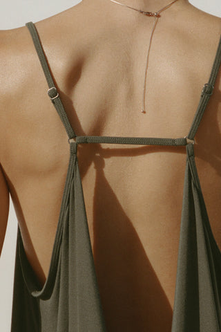 Close up detail back view of model posing in the flowy and relaxed spruce modal Open Back Slip Tank with and open back, adjustable straps and back button closures for a customizable fit.
