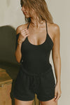 Front view of model posing in the fitted black modal Open T-Back Cami featuring spaghetti straps and a scoop neckline
