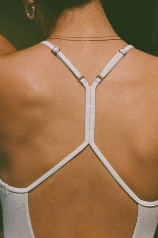 Close up detail back view of model posing in the fitted chalk modal Open T-Back Cami with an open t-back design