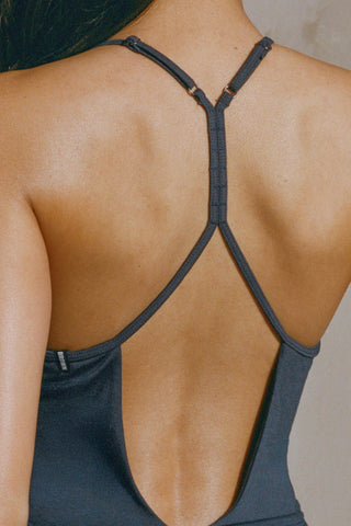 Close up detail back view of model posing in the fitted navy modal Open T-Back Cami with an open t-back design