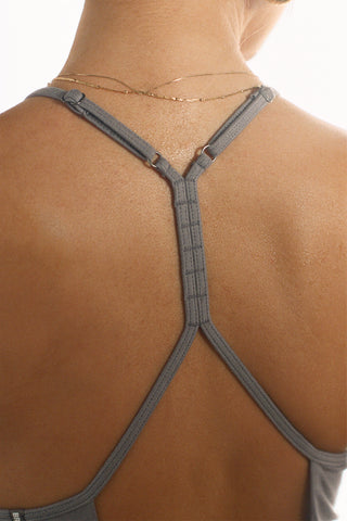 Back close up view of model posing in the fitted shadow modal Open T-Back Cami featuring spaghetti straps and a scoop neckline