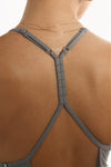 Back close up view of model posing in the fitted shadow modal Open T-Back Cami featuring spaghetti straps and a scoop neckline