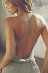 Back view of model posing in the fitted shadow modal Open T-Back Cami with an open t-back design