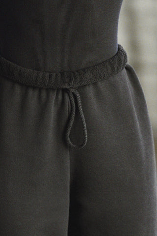 Close up detail front view of model from the waist down wearing the oversized loose fit black french terry Oversized Jogger with an elastic waistband and ankle cuffs