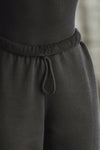 Close up detail front view of model from the waist down wearing the oversized loose fit black french terry Oversized Jogger with an elastic waistband and ankle cuffs
