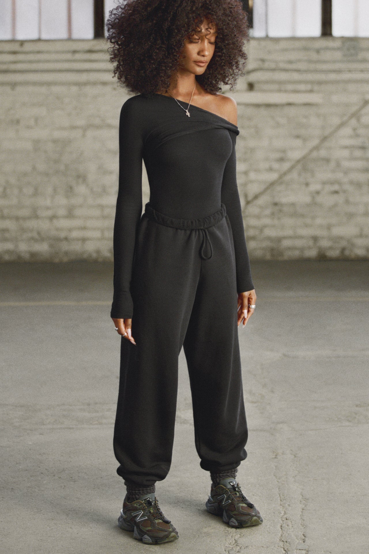 Full body front view of model posing in  the oversized loose fit black french terry Oversized Jogger with an elastic waistband and ankle cuffs