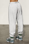 Bacj view of model from the waist down posing in the oversized loose fit pearl grey french terry Oversized Jogger with an elastic waistband and ankle cuffs