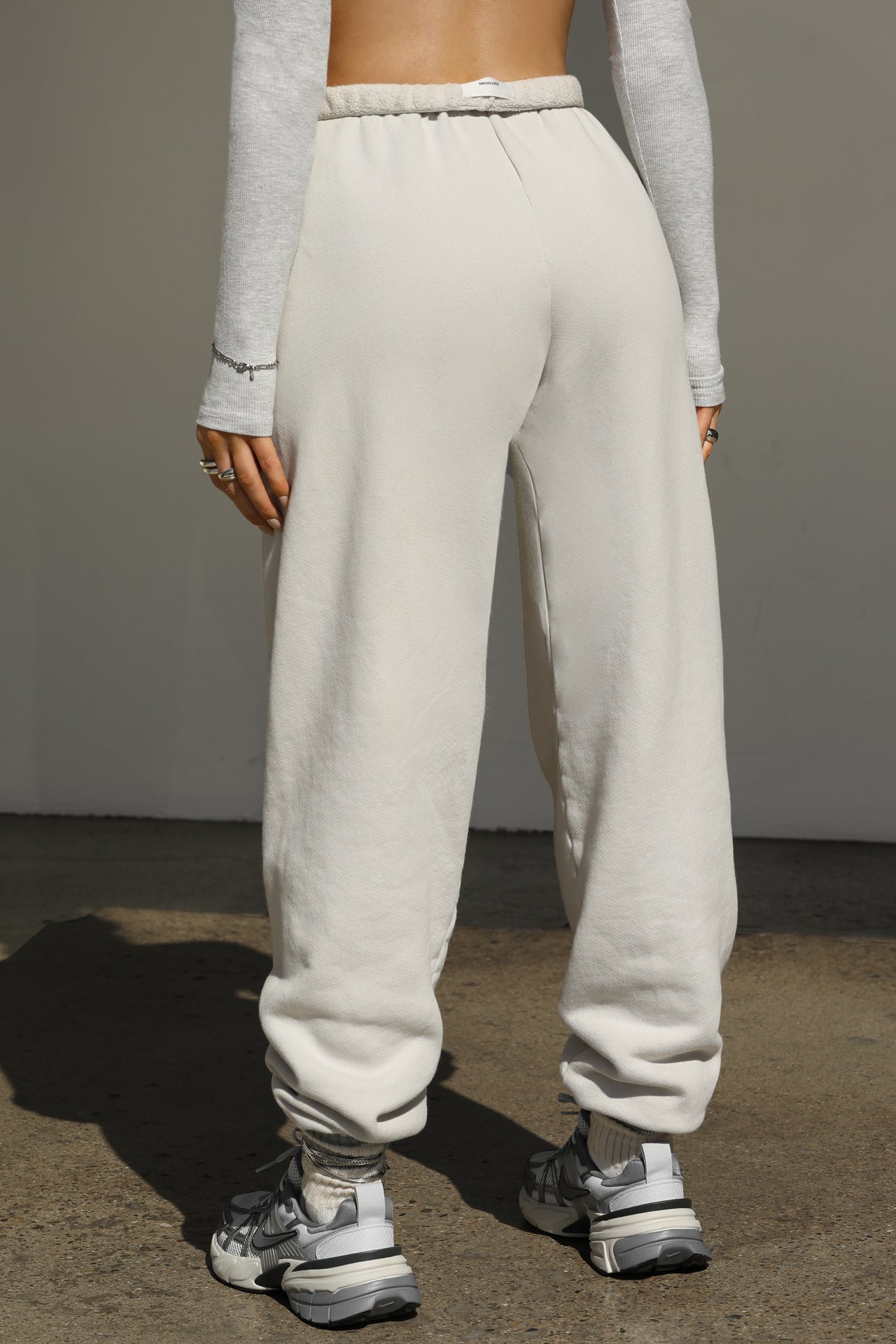 Back view of model from the waist down wearing the oversized loose fit sahara french terry Oversized Jogger with an elastic waistband and ankle cuffs