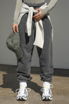 Front view of model from the waist down wearing the oversized loose fit washed black french terry Oversized Jogger with an elastic waistband and ankle cuffs